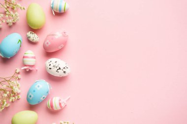 Paskalya arkaplanı pembeye uzanıyordu. Kopya alanı olan renkli yumurta ve çiçekler.