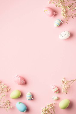 Paskalya yumurtaları pembe arka planda. Renkli yumurtalar, çiçekler. Kopyalama alanı olan düz.