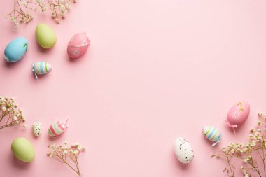 Paskalya yumurtaları pembe arka planda. Renkli yumurtalar, çiçekler. Kopyalama alanı olan düz.