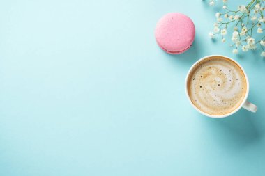 Mavi arka planda bir fincan kahve ve kurabiye. Kopyalama alanı olan düz.