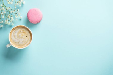 Mavi arka planda bir fincan kahve ve kurabiye. Kopyalama alanı olan düz.