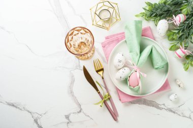 Paskalya yemeği geçmişi, beyaz arka planda tatil masası ayarı. Beyaz tabak, çatal bıçak takımı ve paskalya süslemeleri..