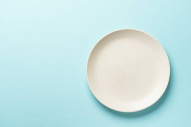 Mavi arka planda beyaz plaka. Üst görünüm.