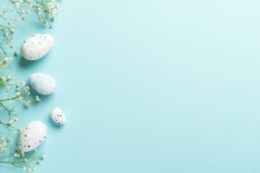 Paskalya düzlüğü, mavi üzerine yumurtalar ve çiçekler serilmiş..