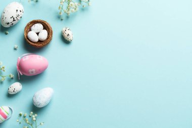 Paskalya arkaplanı, egolar, dekorasyonlar ve çiçekler. Mavi arka planda düz uzandı.