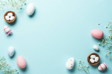 Paskalya arkaplanı, egolar, dekorasyonlar ve çiçekler. Mavi arka planda düz uzandı.