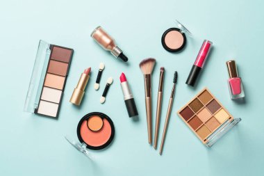 Mavi arka planda profesyonel makyaj ürünleri. Düz yatıyordu.