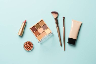 Mavi arka planda profesyonel makyaj ürünleri. Düz yatıyordu.