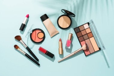 Mavi arka planda profesyonel makyaj ürünleri. Düz yatıyordu.