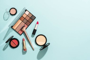Mavi arka planda profesyonel makyaj ürünleri. Düz yatıyordu.