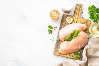 Çiğ tavuk eti, beyaz arka planda baharatlı tavuk filetosu. Metin için boşluk olan üst görünüm.