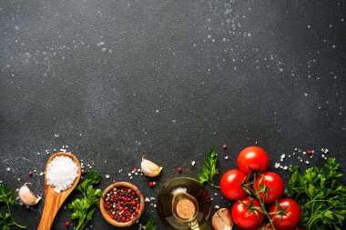 Mutfak masasında pişirmek için gerekli malzemeler organik sebzeler, zeytinyağı, otlar ve baharatlar..