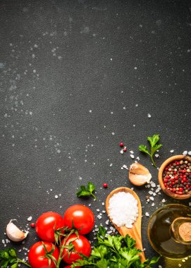 Siyah taş masadaki sağlıklı yemek geçmişi. Organik sebzeler, zeytinyağı, otlar ve baharatlar. Kopyalama alanı olan üst görünüm.