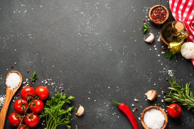 Siyah taş masadaki sağlıklı yemek geçmişi. Organik sebzeler, zeytinyağı, otlar ve baharatlar. Kopyalama alanı olan üst görünüm.