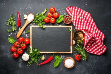 Siyahın sağlıklı yemek geçmişi. Taze sebzeler, bitkiler, baharatlar ve zeytinyağı. Kopyalama alanı olan düz.