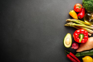 Siyah arka planda sebzeler. Paprika, argus, domates, brokoli ve avokado. Kopyalama alanı olan düz.