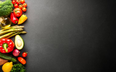 Siyah arka planda sebzeler. Paprika, argus, domates, brokoli ve avokado. Sağlıklı yemek, vejetaryen yemeği.