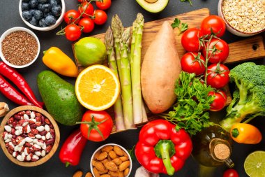 Taze sebze, meyve, tahıl, yaprak ve fındık. Siyah üzerine üst görünüm.