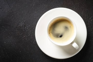 Kahve fincanı. Siyah masada beyaz bardakta espresso. En üst görüntü.