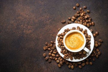Cup of coffee and roasted coffee beans at dark table . Top view with copy space.
