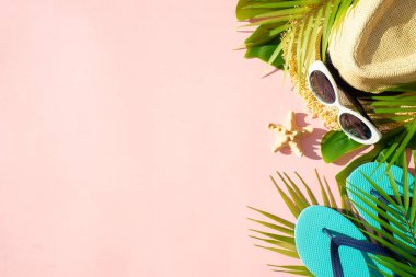 Pembe arka planda palmiye yaprakları olan yazlık kumaş ve aksesuarlar. Dizayn için alanı olan düz uzandı.