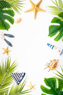 Yaz düzlüğü arka plandaydı. Yaz tatili ve seyahat konsepti. Palmiye yaprakları, deniz kabukları ve beyaz arka planda dekor.