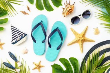 Yaz düzlüğü arka plandaydı. Yaz tatili ve seyahat konsepti. Palmiye yaprakları, deniz kabukları ve beyaz arka planda dekor.