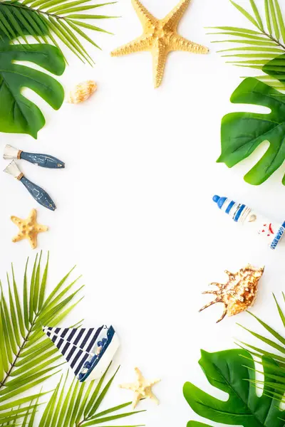Yaz düzlüğü arka plandaydı. Yaz tatili ve seyahat konsepti. Palmiye yaprakları, deniz kabukları ve beyaz arka planda dekor.