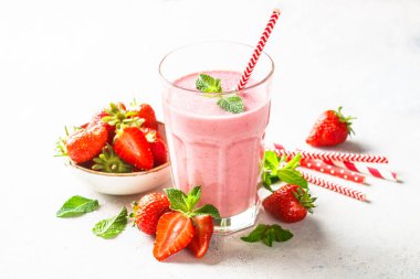 Çilekli smoothie veya beyaz masada taze böğürtlenli milkshake..