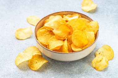 Beyaz masada tahta kasede patates cipsi. Kopyalama alanı olan üst görünüm.