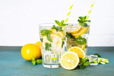 Limonata bardakta beyaz masada taze limon ve nane ile. Soğuk yaz içeceği.