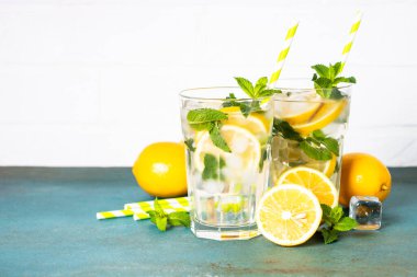 Limonata bardakta beyaz masada taze limon ve nane ile. Soğuk yaz içeceği.
