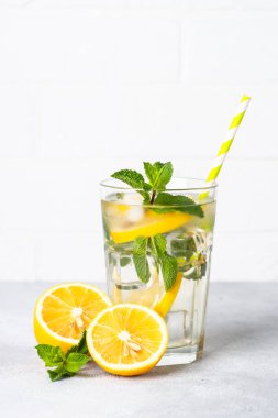 Beyaz masada cam içinde limonata. Buzlu soğuk yaz içkisi.