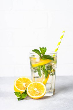 Beyaz masada cam içinde limonata. Buzlu soğuk yaz içkisi.