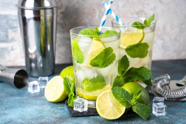 Siyah arka planda rom, nane ve limon ile mojito. Geleneksel yaz içkisi, titretici ve bar aletleriyle..