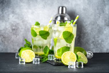 Siyah arka planda rom, nane ve limon ile mojito. Geleneksel yaz içkisi, titretici ve bar aletleriyle..
