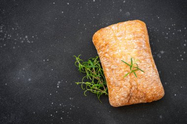 Ciabatta ekmeği tahtada, siyah arka planda. Kopyalama alanı olan üst görünüm.