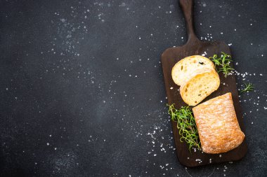 Ciabatta ekmeği tahtada, siyah arka planda. Kopyalama alanı olan üst görünüm.