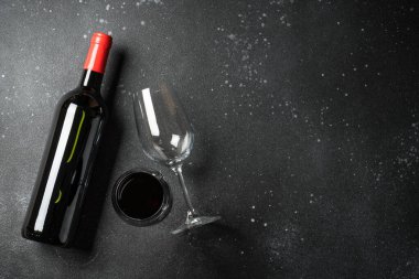 Siyah arka planda şarap şişesi ve şarap kadehi. Kopyalama alanı olan üst görünüm.