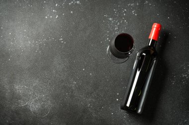 Siyah arka planda şarap şişesi ve şarap kadehi. Düz görünüm.