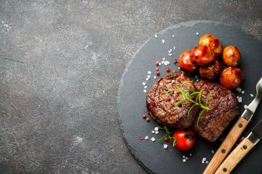 Sebzeli et biftekleri ve siyah arka planda otlar. Kopyalama alanı olan en üst görüntü.