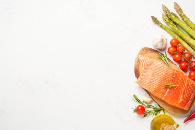 Taze sebzeli somon filetosu. Pişirmek için ham malzemeler. Beyaz arkaplanda üst görünüm.