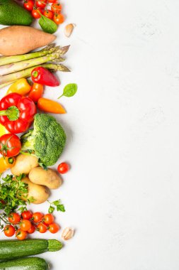 Beyaz mutfak masasında taze sebzeler. Kopyalama alanı olan üst görünüm, dikey.