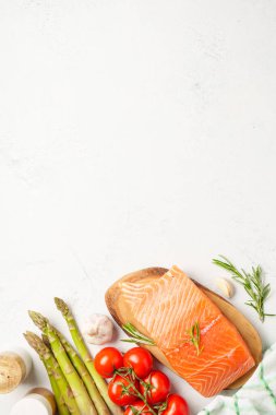 Taze sebzeli somon filetosu. Pişirmek için ham malzemeler. Beyaz arkaplanda kopyalama alanı olan üst görünüm.