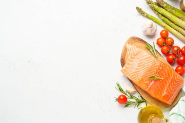 Taze sebzeli somon filetosu. Pişirmek için ham malzemeler. Beyaz arkaplanda kopyalama alanı olan üst görünüm.