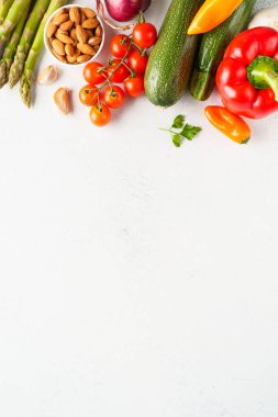 Beyaz arka planda sebzeler. Paprika, kuşkonmaz, domates, brokoli ve avokado. Üst görünüm, dikey.