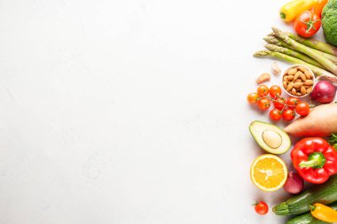 Beyaz arka planda sebzeler. Sağlıklı yemekler, vejetaryen yemekleri, manzarası. Paprika, kuşkonmaz, domates, brokoli ve avokado..