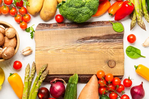 Beyaz üzerine vejetaryen yemeği. Taze sebzeler - Paprika, kuşkonmaz, domates, brokoli, patates ve avokado.