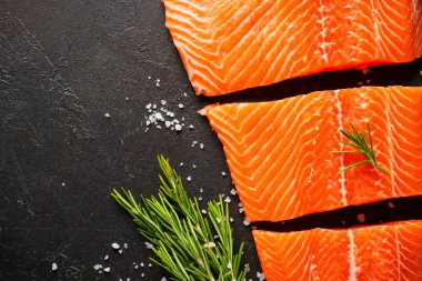 Somon balığı. Çiğ somon filetosu. Siyah arkaplanda üst görünüm.