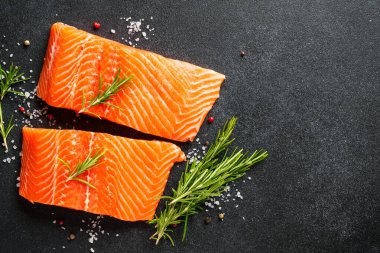 Baharatlı çiğ somon filetosu. Siyah arkaplanda kopyalama alanı olan üst görünüm.